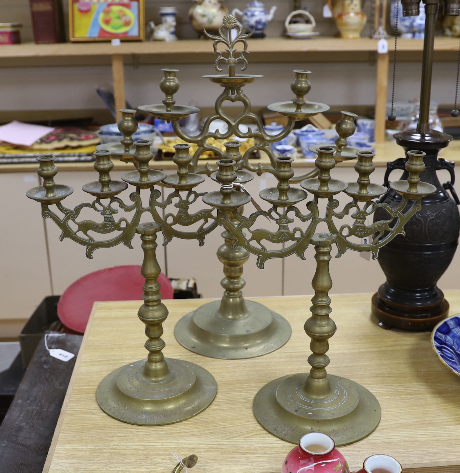 Judaica - a pair of Polish brass candelabra and a similar larger candelabrum, tallest 63cm (3)